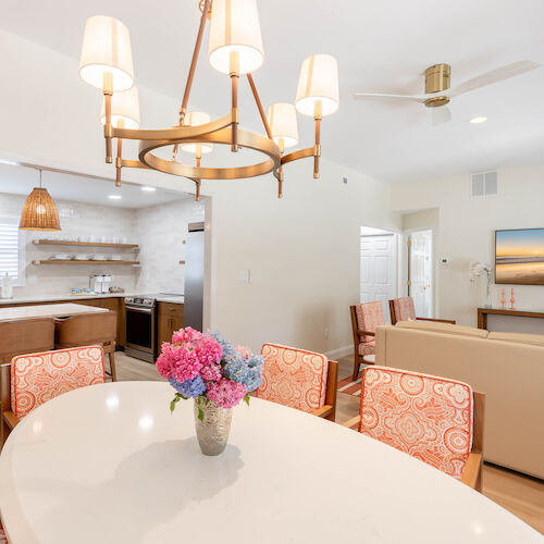 This image shows a bright open-concept living space with a dining area, kitchen, and living room.