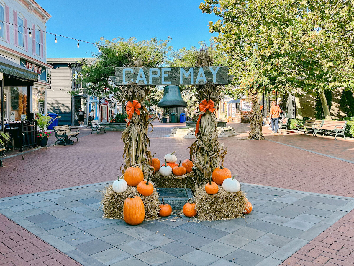 A festive outdoor display with pumpkins, hay, and a 