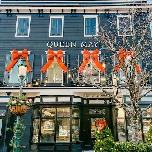 A decorated three-story building with large red bows, festive lights, and a sign reading 